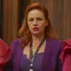 Karine Teles como Aldeíde em Vale Tudo, segurando duas peças de roupa nas mãos