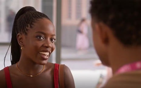 A atriz Clara Moneke sorrindo em frente ao ator Juan Paiva em cena de Dona de Mim