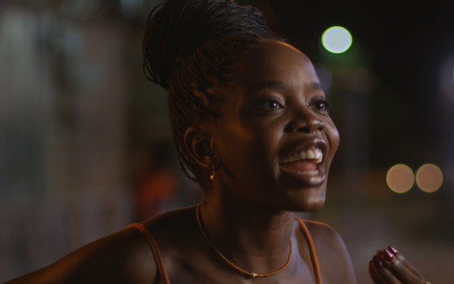 A atriz Clara Moneke com expressão empolgada em cena de Dona de Mim