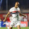 Lucas Moura faz movimento de chute na bola em jogo do São Paulo; ele usa o uniforme tradicional do clube