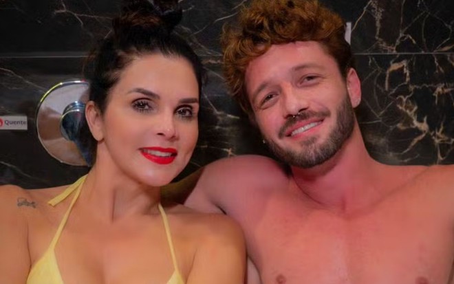 Luiza Ambiel e Diogo Venturieri, sorridentes, lado a lado, dentro de uma banheira; ela usa biquíni amarelo e ele aparece sem camisa