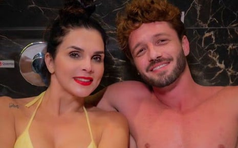 Luiza Ambiel e Diogo Venturieri, sorridentes, lado a lado, dentro de uma banheira; ela usa biquíni amarelo e ele aparece sem camisa
