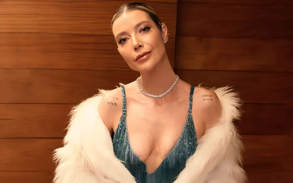 Luiza Possi posando com um vestido azul de alças finas e casaco de plumas