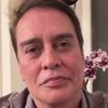 Dois frames de Marcello Antony em vídeo do Instagram; ele aparece de camisa pontilhada vinho e branca e uma orquídea rosa ao fundo