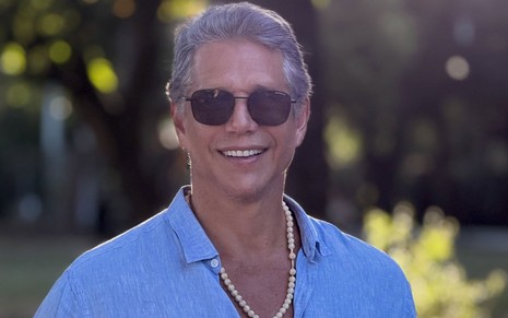 Marcio Garcia usa óculos escuros e uma camisa azul