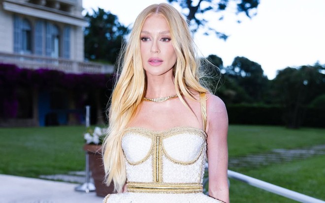 Marina Ruy Barbosa posando no baile da amfAR, em Cannes; ela está de cabelo loiro, vestido decotado e o braço esquerdo dela aparece totalmente roxo