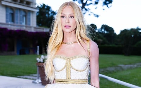 Marina Ruy Barbosa posando no baile da amfAR, em Cannes; ela está de cabelo loiro, vestido decotado e o braço esquerdo dela aparece totalmente roxo