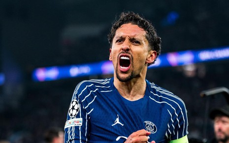 Zagueiro Marquinhos, do PSG, grita e mostra o escudo do time enquanto comemora gol