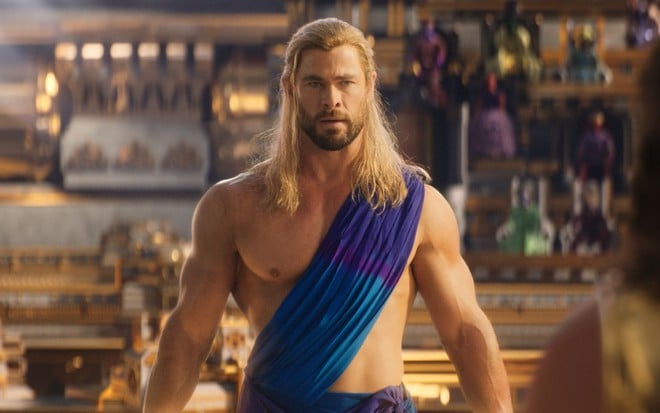 Chris Hemsworth está sem camisa, com uma túnica cobrindo parte de seu ombro