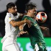 Jogadores disputando uma partida de futebol, com um atleta do Santos (uniforme branco) enfrentando um do Palmeiras (uniforme verde).