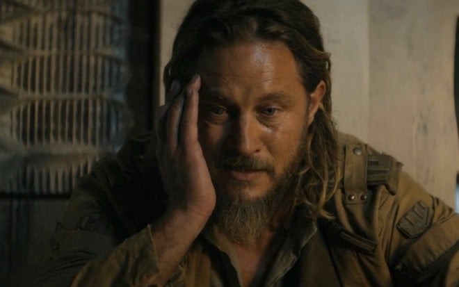 Travis Fimmel apoia sua cabeça na mão, com expressão pensativa, em cena de Duna: Profecia