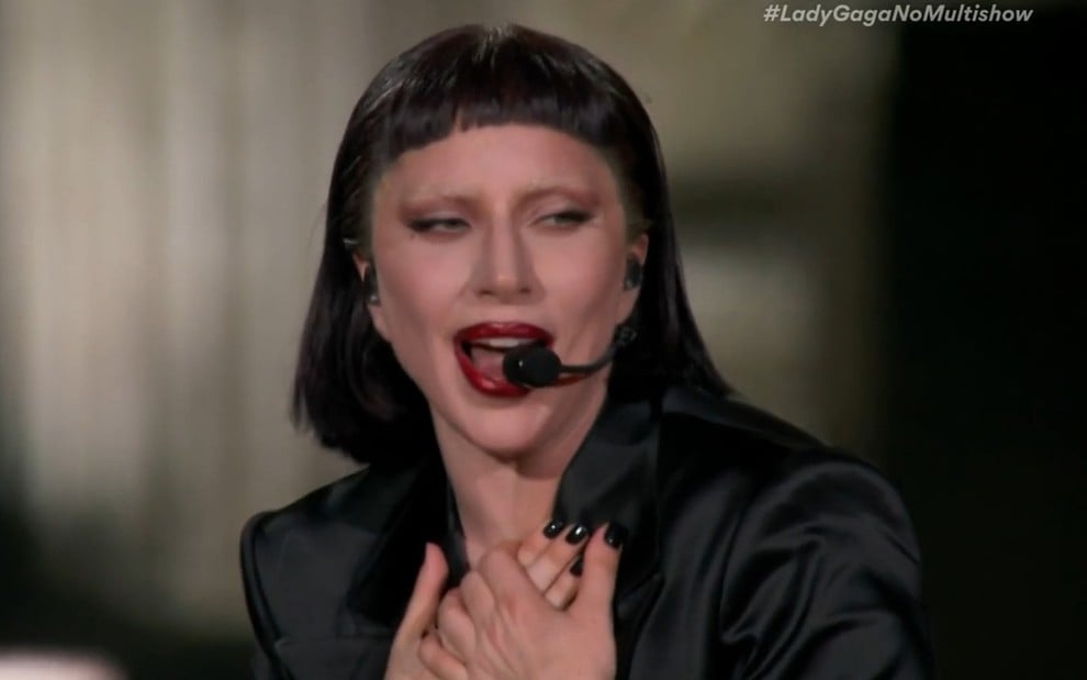 Lady Gaga canta com peruca preta e batom bem vermelho