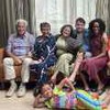 Elenco principal da nova versão da série infantil Mundo da Lua posando para foto, adultos sentados no sofá e menina deitada no chão