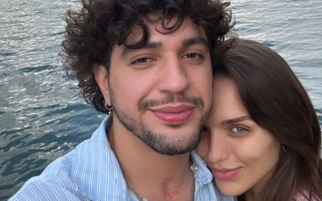 Nattan e Rafa Kalimann estão com os rostos colados e posam para selfie; ao fundo é possível ver um lago