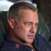 Taylor Kinney está sentado em poltrona com expressão séria em cena de Chicago Fire