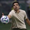 O técnico Abel Ferreira faz movimento para segurar a bola em jogo do Palmeiras; ele usa uma camisa polo bege