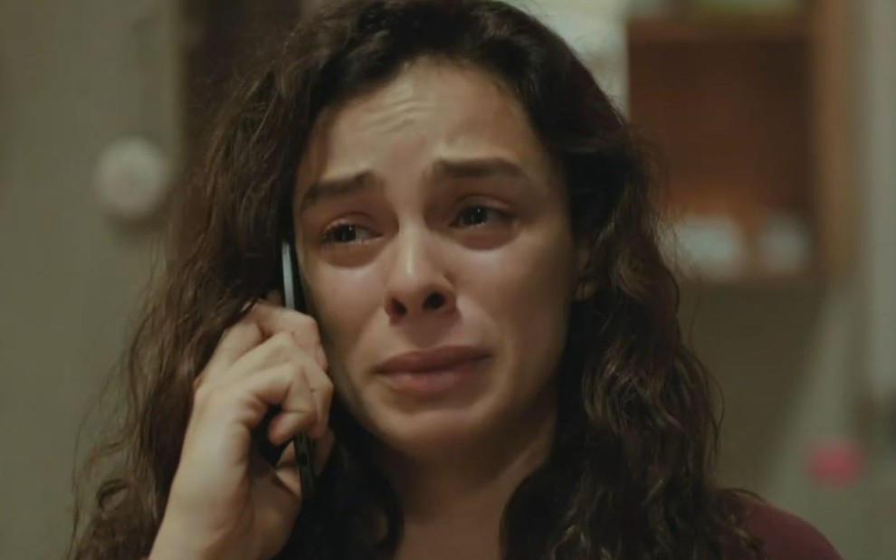 Bahar (Özge Özpirinçci) está no celular e chora em cena da novela Força de Mulher