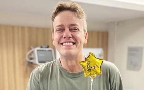 Pablo Sanábio no hospital, sorridente, segurando um pequeno balão em formato de estrela amarela, escrito 'fim'