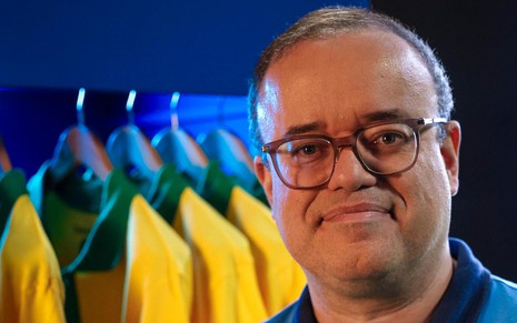 Everaldo Marques posa com camisas da Seleção Brasileira ao fundo
