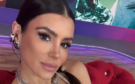 Mulher faz carão para selfie em um cenário roxo