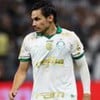 Raphael Veiga, do Palmeiras, veste uniforme branco com detalhes verdes e dourados durante jogo