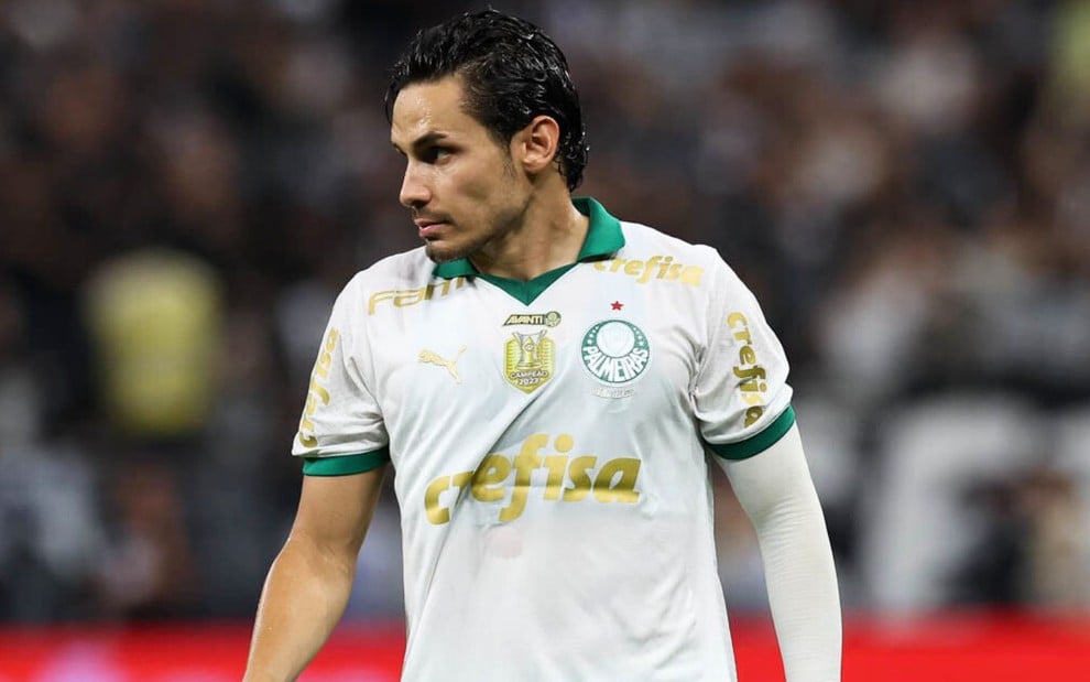 Raphael Veiga, do Palmeiras, veste uniforme branco com detalhes verdes e dourados durante jogo