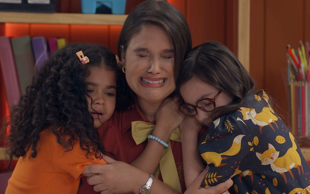 Elisa (Pamella Machado) é abraçada por duas meninas em cena da novela A Caverna Encantada