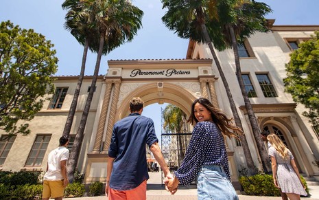 Pessoas se preparam para entrar no Paramount Studios, com portal de entrada em destaque