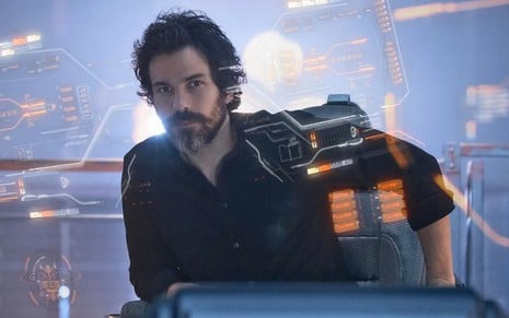 Santiago Cabrera tem expressão compenetrada no comando de uma nave espacial