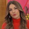 Patrícia Poeta sentada no cenário do Encontro, usando vestido vermelho com gola alta