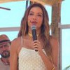 A apresentadora Patrícia Poeta debaixo de uma cabana em uma praia