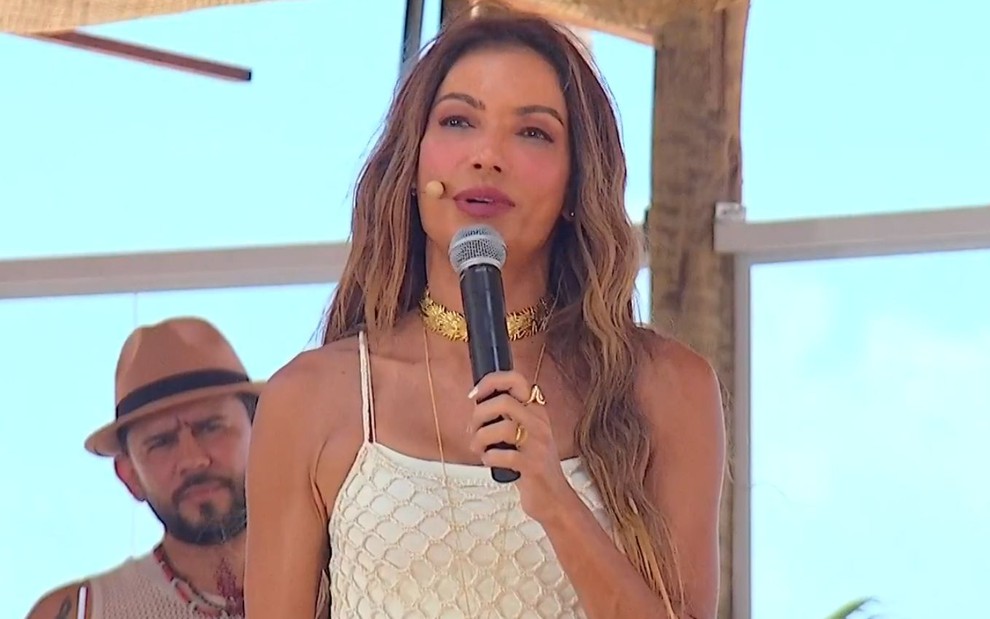 A apresentadora Patrícia Poeta debaixo de uma cabana em uma praia