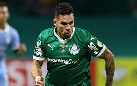 Jogador do Palmeiras, Paulinho usa uniforme verde tradicional do clube; ele faz movimento de corrida em jogo
