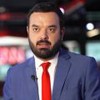 Pedro Duran usa terno cinza e gravata vermelha; ao fundo está a Redação da CNN Brasil