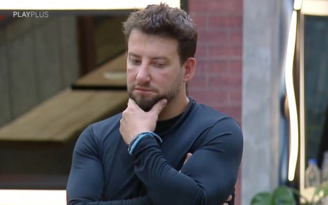 Eros Prado tem expressão concentrada na sala do Power Couple
