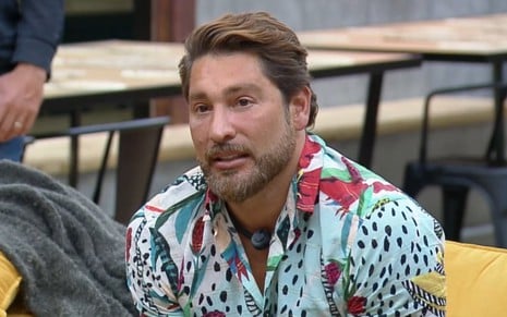Victor Pecoraro tem expressão de preocupação na sala do Power Couple