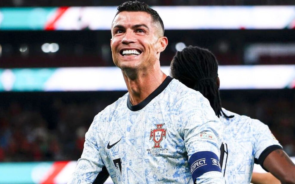 Cristiano Ronaldo veste uniforme branco com detalhes azuis e pretos durante jogo de Portugal