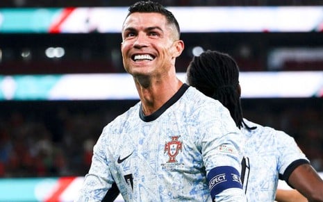 Cristiano Ronaldo veste uniforme branco com detalhes azuis e pretos durante jogo de Portugal