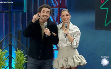 Felipe Andreoli e Rafa Brites no Power Couple Brasil, com microfones em mãos