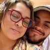 Preta Gil e o filho, Francisco Gil; eles dão um leve sorriso no hospital. A artista usa um óculos de aros vermelhos e uma blusa amarela; já o cantor está com uma blusa branca e um boné da mesma cor