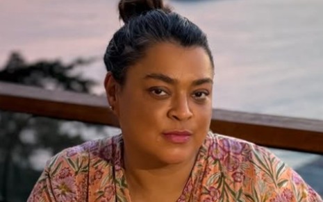 Preta Gil com o cabelo preso em um coque, em cenário de mar