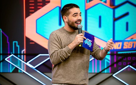 menino branco fala no microfone em estúdio de TV