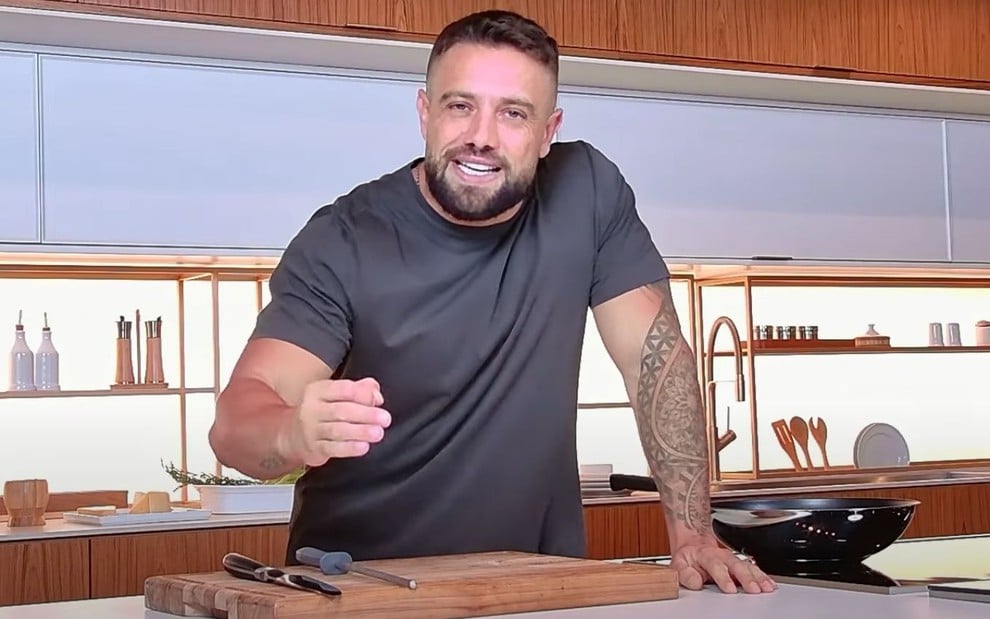 Rafael Cardoso em uma cozinha, usando camiseta cinza