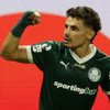 Raphael Veiga usa o uniforme verde do Palmeiras e está com braço levantado em sinal de força