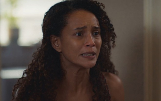 Taís Araujo com expressão séria em cena como Raquel na novela Vale Tudo