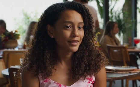 Taís Araujo sorri discretamente em cena como Raquel na novela Vale Tudo