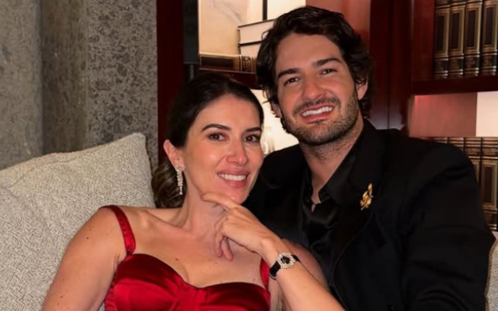 Rebeca Abravanel e Alexandre Pato em trajes de gala e sorridentes; Rebeca usa vestido vermelho e Pato usa terno preto