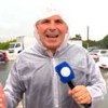 Reinaldo Gottino com capa de chuva e um microfone da Record no meio de uma tempestade no Cidade Alerta