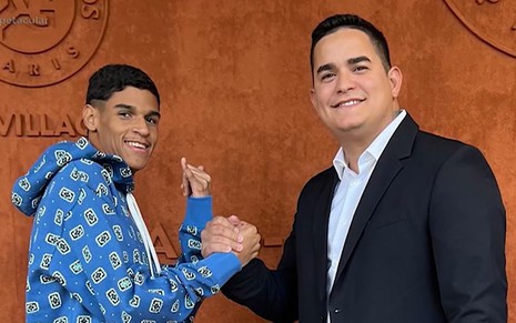 Com roupas casuais, Luva de Pedreiro aperta a mão de Allan Jesus, que usa terno sem gravata