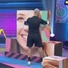 Radamés segura cubo com o rosto de uma mulher no cenário de provas do Power Couple